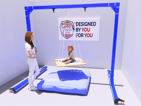 A 3D rendered therapy room scene featuring a Summit Sensory Gym swing frame in bright blue. A child sits on a wooden platform swing while a therapist in white attire observes nearby. Behind them, a banner reads 'DESIGNED BY YOU FOR YOU' with the Summit Sensory Gym logo. A large blue crash pad with the Summit logo lies on the floor. The frame is shown partially disassembled with components laid out on the ground, demonstrating its modular design.