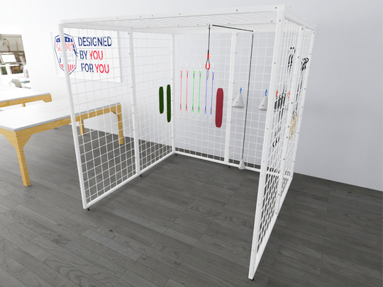 Image of a Summit Sensory Gym Universal Exercise Unit, also referred to as a Spider Cage, featuring a sturdy white metal frame with a grid design on all sides. The setup includes various therapy accessories such as resistance bands, a padded red support, and handles for functional exercises. The background showcases a clean, modern therapy space with a wooden table and a sign that reads 'Designed by You, for You.